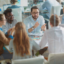 Discussione tra dipendenti in un ambiente collaborativo per migliorare il benessere organizzativo aziendale